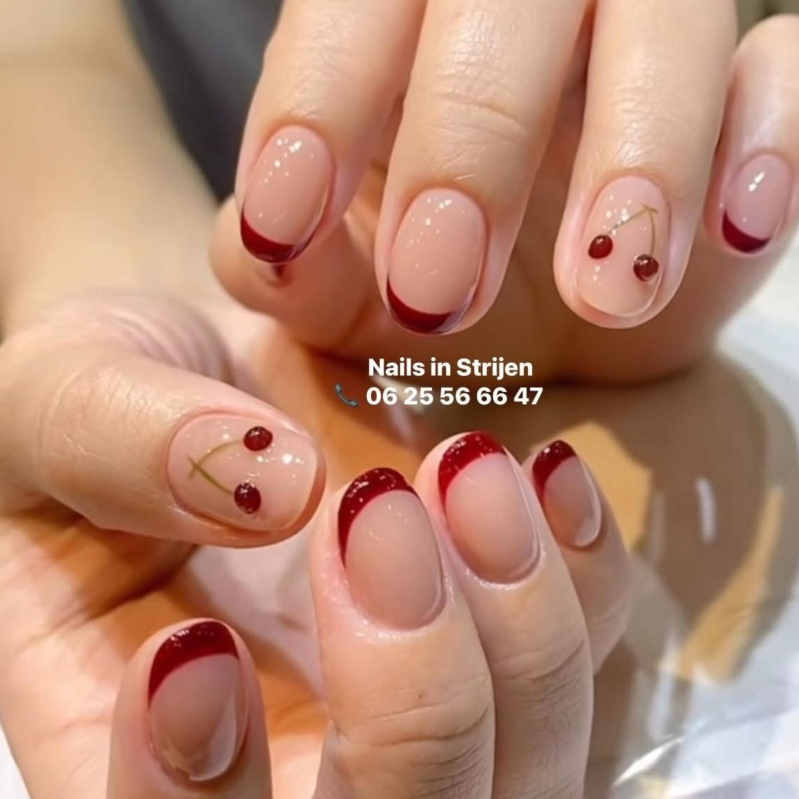 Nude nagels met donkerrode French tips en kersjes
