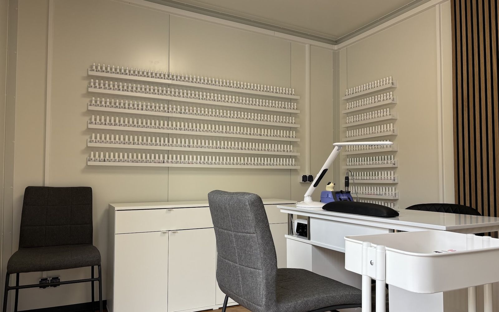 De studio van Linh: een manicuretafel voor een wand met honderden flesjes gellak