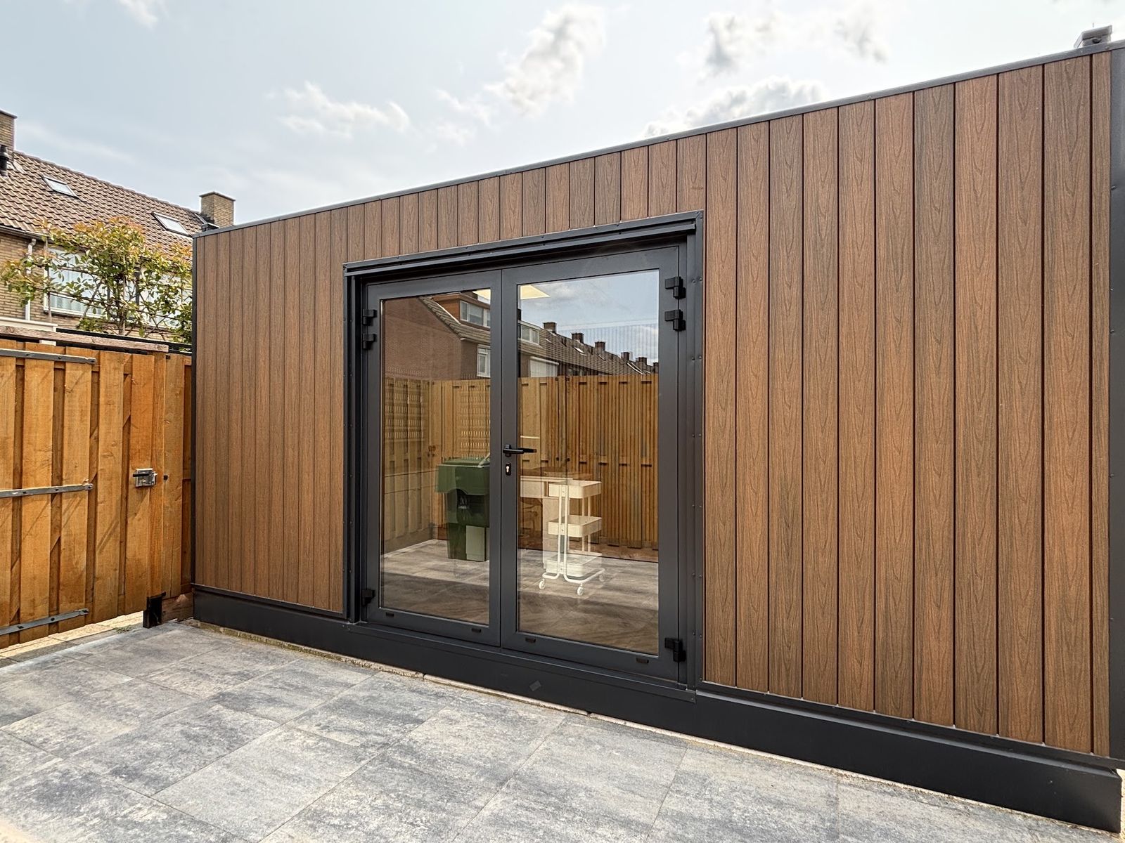 De studio van Nails in Strijen: een houten tuinstudio met dubbele glazen deuren